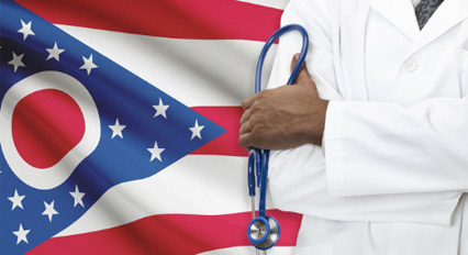 Doctor with a stethoscope standing in-front of the Ohio flag